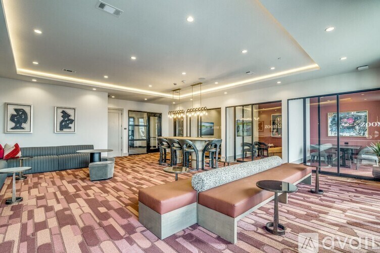 A modern lounge area with a bench, chairs, and a bar.