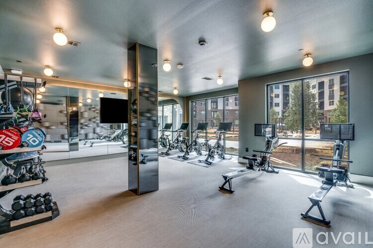 A gym with a variety of equipment including treadmills, weights, and exercise machines.