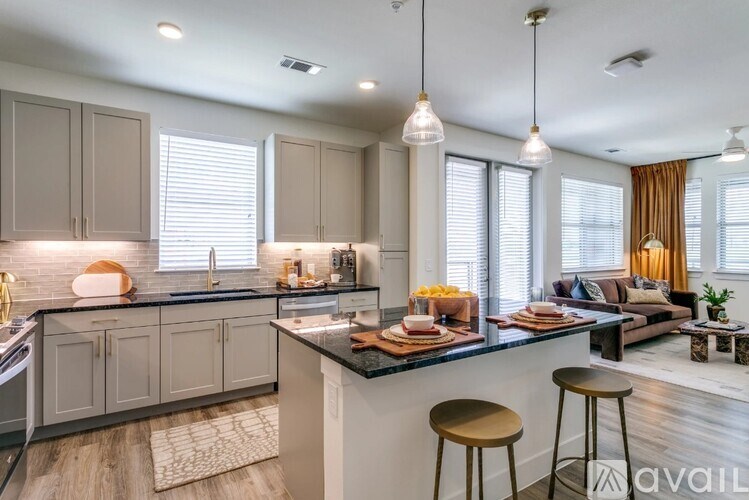 A modern kitchen with a bar stool and a dining area.
