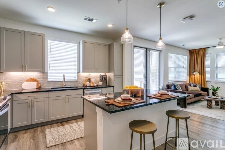 A modern kitchen with a bar stool and a dining area.