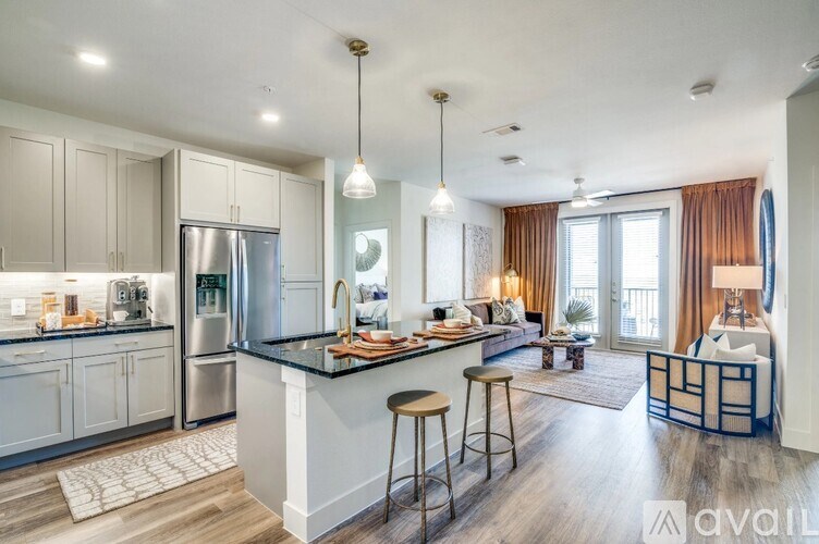 A modern kitchen with a bar and a living room area.