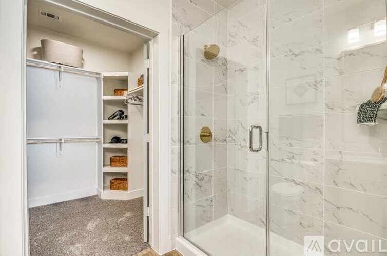 A bathroom with a walk-in shower and a white fridge.