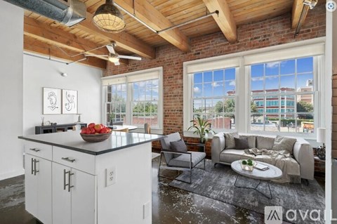 A kitchen with white cabinets and a large window overlooking a cityscape.