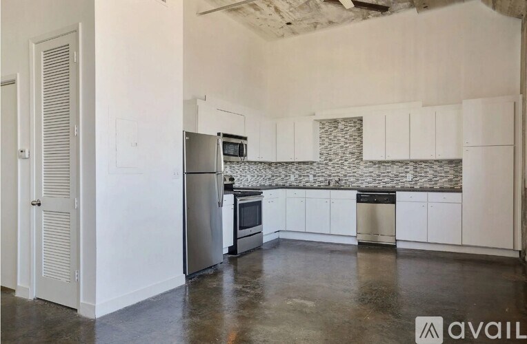 A kitchen with white cabinets and a tiled backsplash.