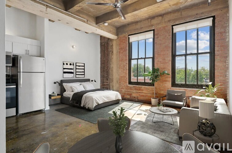 A bedroom with a brick wall and a large bed.