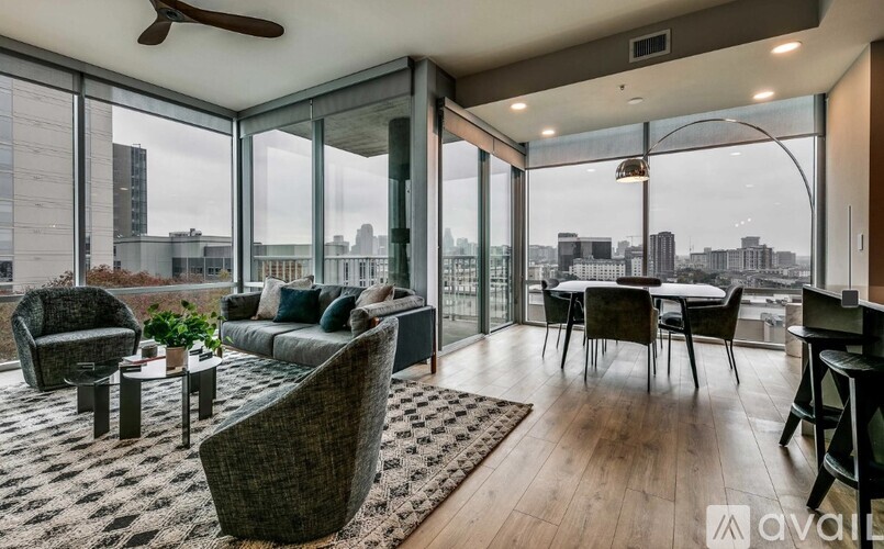 A living room with a view of the cityscape outside the large windows.