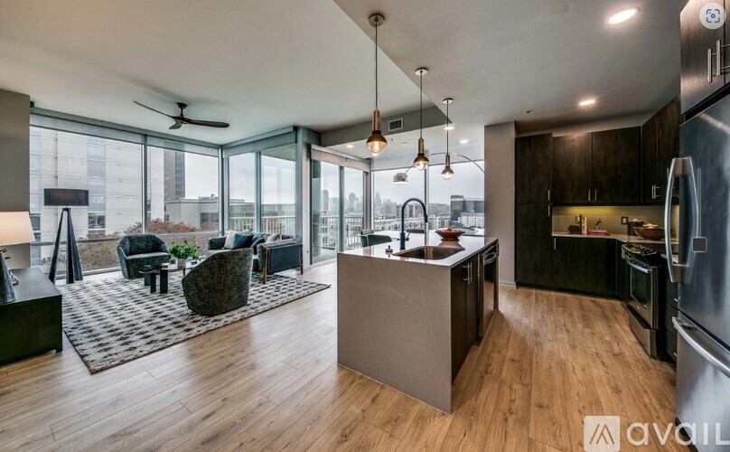 A modern kitchen with a large island and a view of the city.