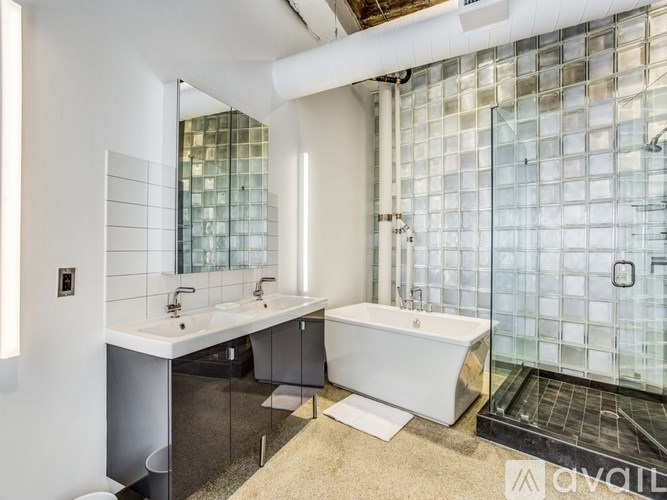 A modern bathroom with a glass block wall and a white sink vanity.