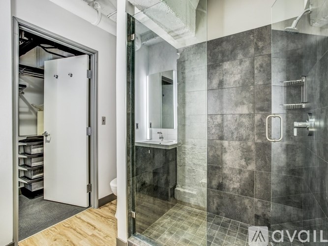 A bathroom with a walk in shower and a white door.