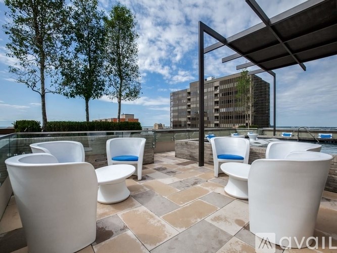 A patio with white chairs and a table with a glass top.