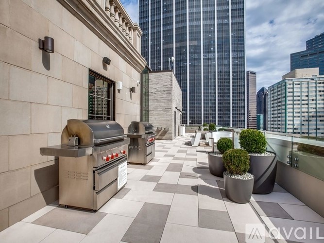 A patio with a grill and potted plants.