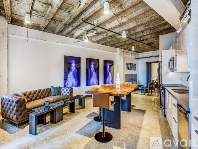 A living room with a brown tufted couch and a wooden table.