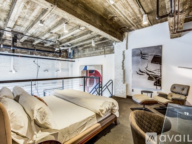 A bedroom with a large bed and a chair.