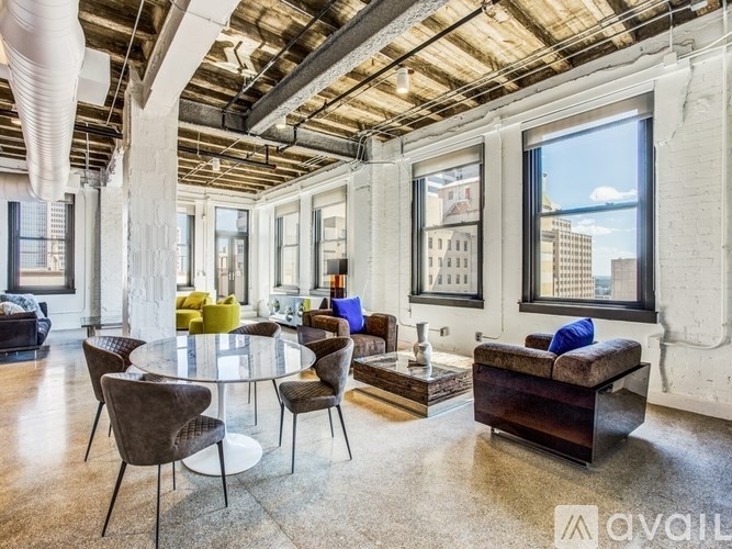 A modern living room with a glass table surrounded by chairs.