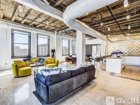 A living room with a grey couch and yellow chairs.