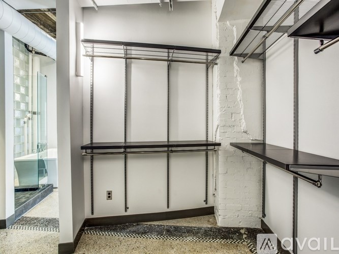 A white wall with a black shelf and a white brick wall.