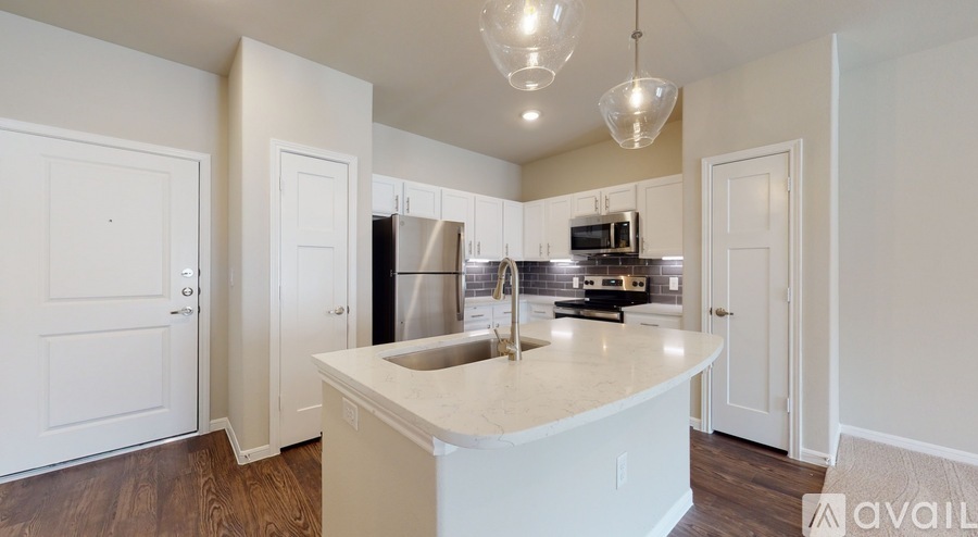 A kitchen with a white island and wooden floors.
