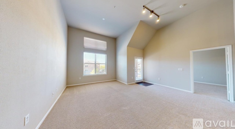 A spacious room with a carpeted floor and a window.