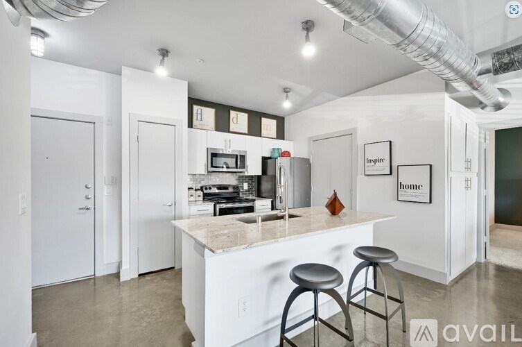 A kitchen with a white counter and bar stools.