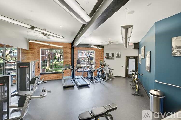 A gym with a variety of equipment including treadmills, weights, and bicycles.
