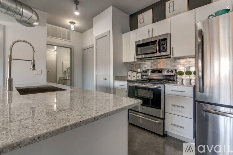 A kitchen with granite countertops and stainless steel appliances.