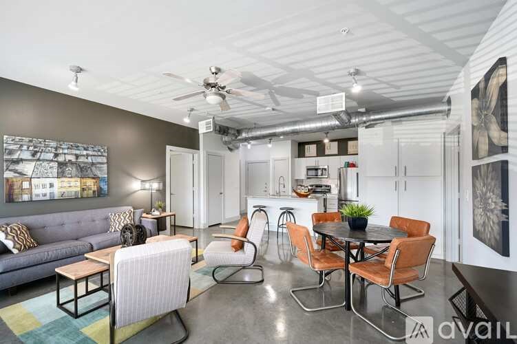 A living room with a grey couch and a glass table.
