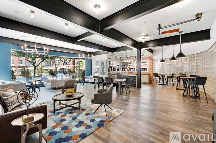 A modern living room with a variety of seating options and a large window.