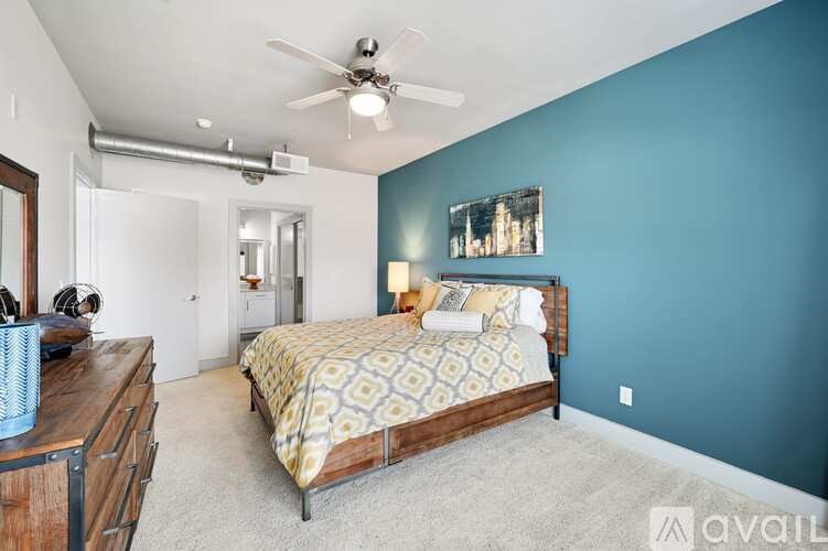 A bedroom with a bed, dresser, and ceiling fan.