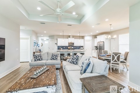 A living room with a white couch and a wooden coffee table.
