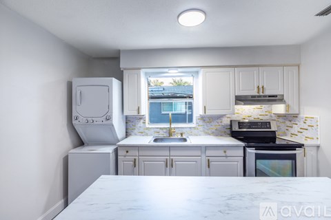 A kitchen with a marble countertop and white cabinets.