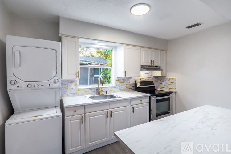 A kitchen with white appliances and cabinets.