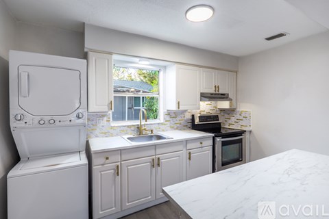 A kitchen with white appliances and cabinets.
