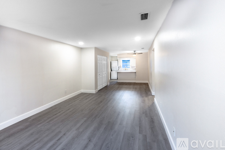 A long hallway with wood floors and white walls.