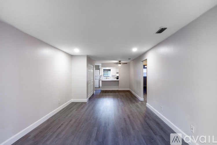 A long, empty hallway with wood floors and white walls.