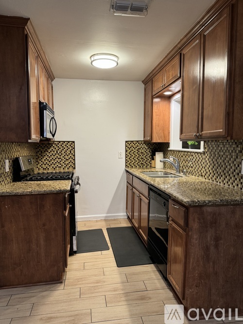 A kitchen with wooden cabinets and a patterned backsplash.