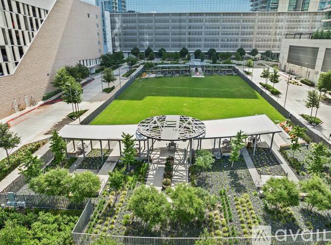 A large open space with a green field and a circular structure in the middle.
