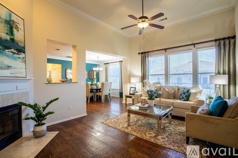 A living room with a fireplace, a sofa, a coffee table, and a painting on the wall.