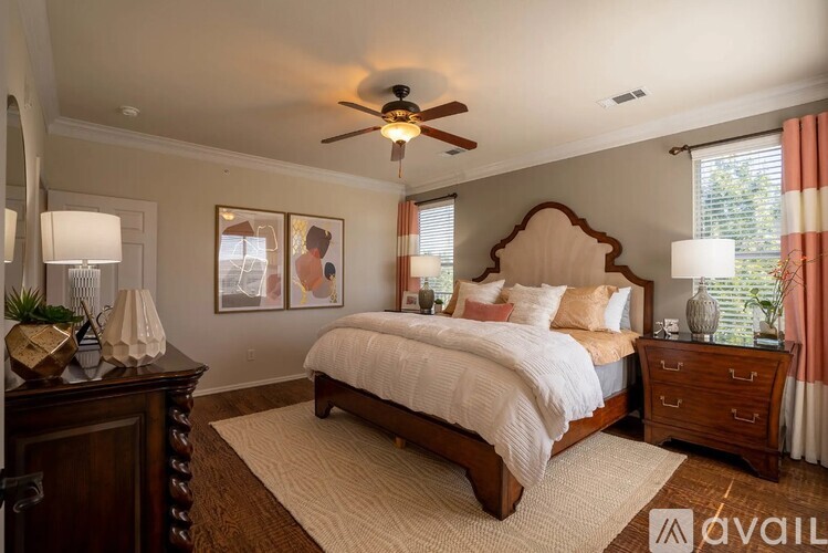 A bedroom with a large bed, a ceiling fan, and a dresser.
