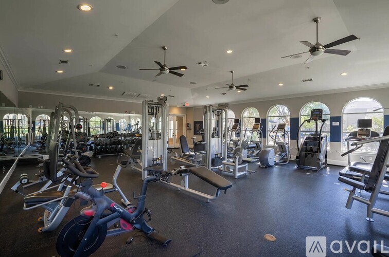 A gym with a variety of equipment including treadmills, weights, and exercise machines.