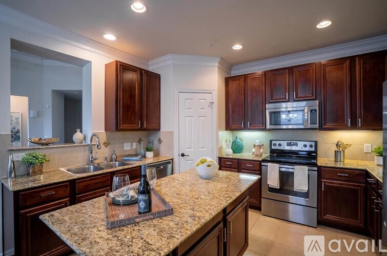 A kitchen with granite countertops and wooden cabinets.