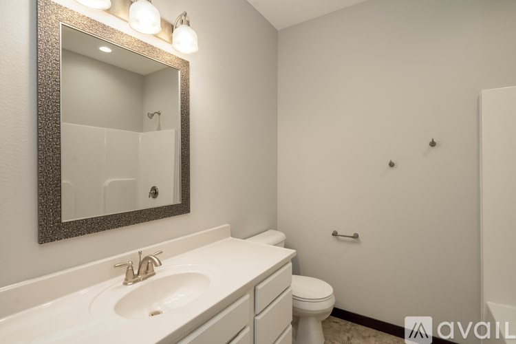 A bathroom with a sink, mirror, and toilet.