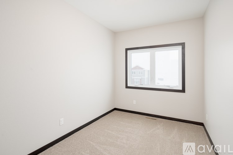 A room with a window and carpeted floor.