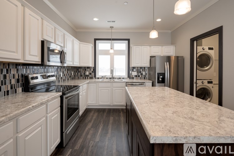 A modern kitchen with a marble countertop and stainless steel appliances.