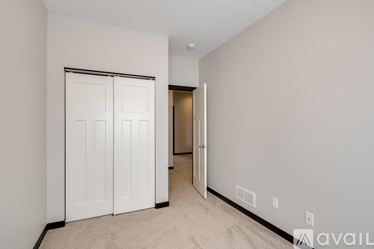 A room with a white door and carpeted floor.