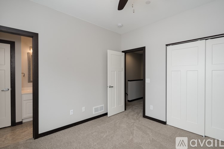 A room with a carpeted floor and a ceiling fan.