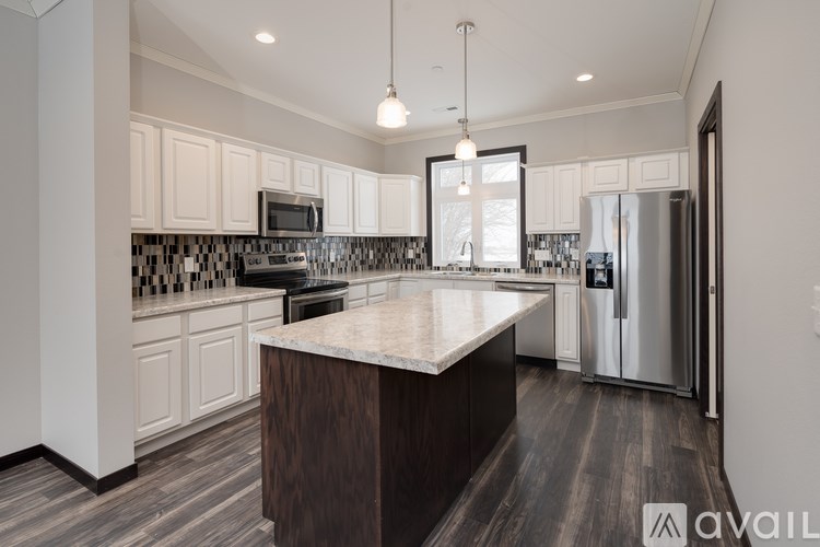 A modern kitchen with a center island and stainless steel appliances.