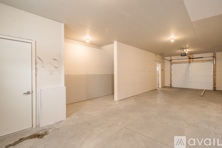 A large empty room with a door on the left and a window on the right.