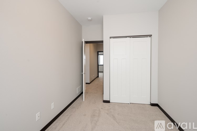 A room with a white door and carpeted floor.