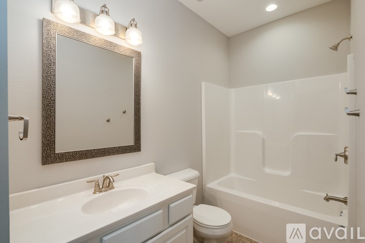 A bathroom with a white tub, sink, and toilet.
