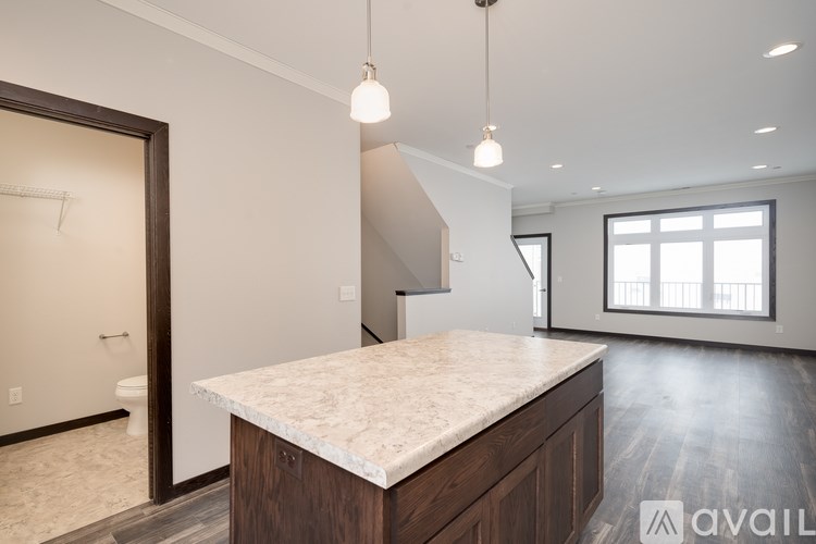 A kitchen with a marble countertop and wooden cabinets.
